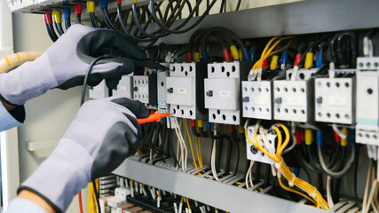 Electrical engineers test electrical installations and wiring on protective relays, measuring them...