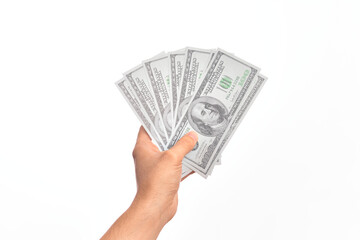 Hand of caucasian young man holding bunch of dollars banknotes over isolated white background