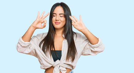 Young beautiful hispanic girl wearing casual clothes relaxed and smiling with eyes closed doing meditation gesture with fingers. yoga concept.