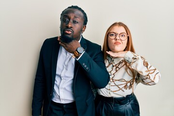 Young interracial couple wearing business and elegant clothes cutting throat with hand as knife, threaten aggression with furious violence