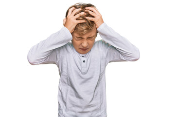 Little caucasian boy kid wearing casual clothes suffering from headache desperate and stressed because pain and migraine. hands on head.