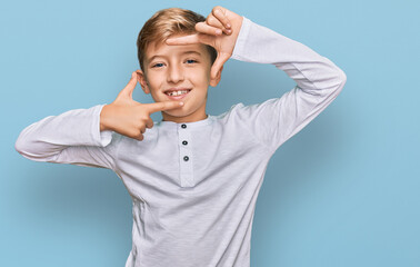 Little caucasian boy kid wearing casual clothes smiling making frame with hands and fingers with happy face. creativity and photography concept.