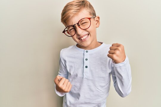 Little caucasian boy kid wearing casual clothes and glasses celebrating surprised and amazed for success with arms raised and eyes closed