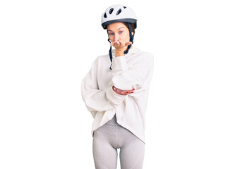 Beautiful brunette young woman wearing bike helmet and sporty clothes looking at the camera blowing a kiss with hand on air being lovely and sexy. love expression.