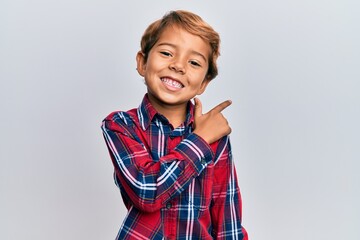Adorable latin kid wearing casual clothes smiling cheerful pointing with hand and finger up to the side