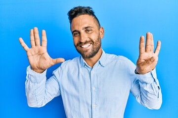 Handsome man with beard wearing casual clothes showing and pointing up with fingers number nine...