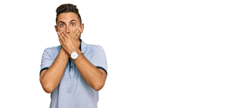 Handsome man with beard wearing casual clothes shocked covering mouth with hands for mistake. secret concept.