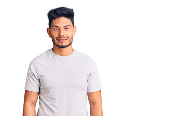 Handsome latin american young man wearing casual tshirt with a happy and cool smile on face. lucky person.