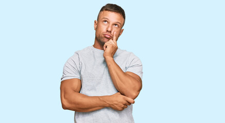 Handsome muscle man wearing casual grey tshirt serious face thinking about question with hand on...