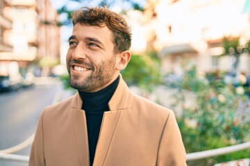 Handsome business man wearing elegant jacket smiling happy outdoors