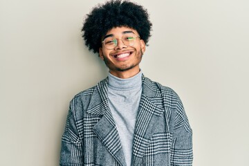 Fototapeta na wymiar Young african american man with afro hair wearing casual clothes glasses with a happy and cool smile on face. lucky person.