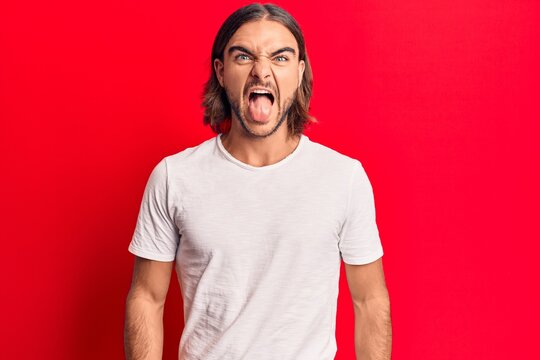 Young handsome man wearing casual clothes sticking tongue out happy with funny expression. emotion concept.