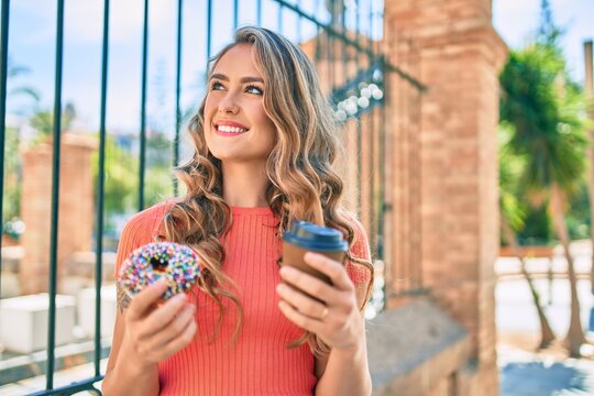 Young blonde girl smiling happy having breakfast at the city.