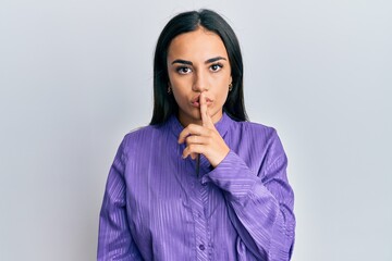 Young brunette woman wearing casual clothes asking to be quiet with finger on lips. silence and secret concept.