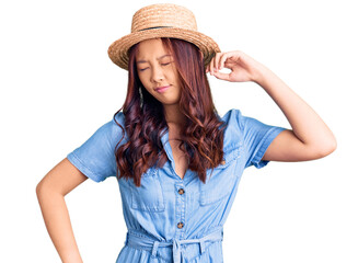 Obraz na płótnie Canvas Young beautiful chinese girl wearing summer hat stretching back, tired and relaxed, sleepy and yawning for early morning