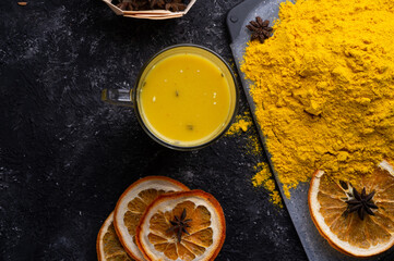 Curcuma (turmeric) spice , curcuma cocktail served with dry oranges at black table. Food and cuisine ingredients. healthy concept. . flat lay