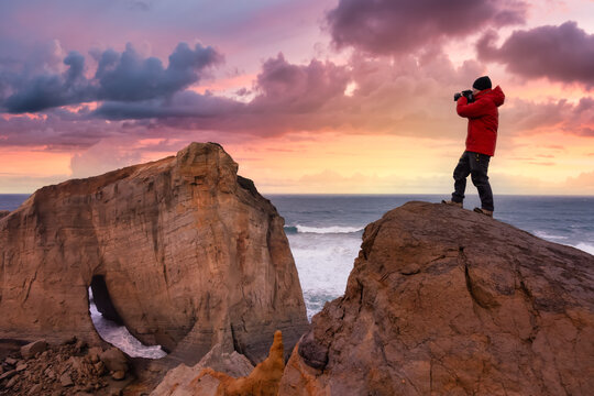 Photographer is taking pictures of the beautiful seaside view on the Oregon Coast. Taken in Cape Kiwanda, Pacific City, during a cloudy winter Sunset.