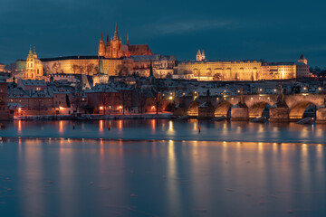 Fototapeta na wymiar .Charles Bridge on the Vltava River and Prague Castle and the Church of St. Vitus in winter and snow on the roofs in the center of Prague in the early evening