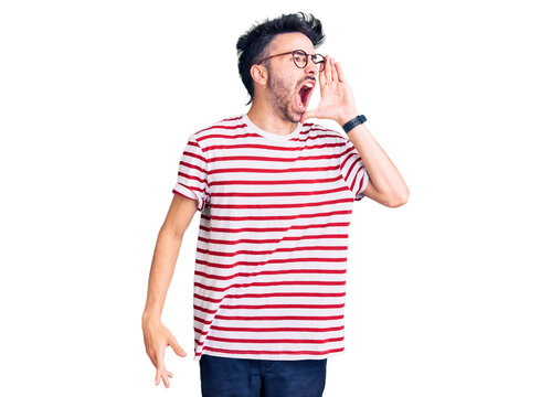 Young hispanic man wearing casual clothes shouting and screaming loud to side with hand on mouth. communication concept.