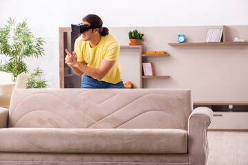 Young man student with virtual glasses at home