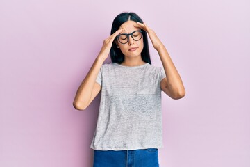 Beautiful young woman wearing casual clothes and glasses with hand on head, headache because stress. suffering migraine.