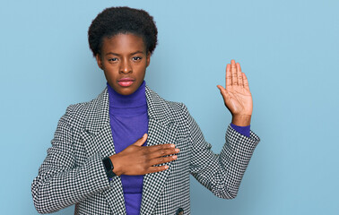 Young african american girl wearing casual clothes swearing with hand on chest and open palm,...