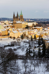 Fototapeta premium Snowy Prague City with gothic Castle from Hill Petrin in the sunny Day, Czech republic