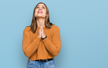 Beautiful caucasian woman wearing casual clothes begging and praying with hands together with hope...