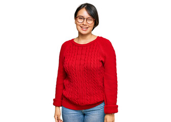 Young beautiful hispanic woman with short hair wearing casual sweater and glasses winking looking...