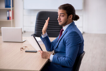 Young male employee sitting in the office in front of whiteboard