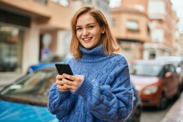 Young caucasian girl smiling happy using smartphone at the city.