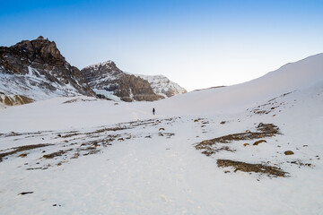 View of a woman walking towards the Athabasca glacier in the Canadian Rockies
