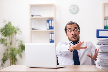 Young businessman unhappy with excessive work in the office