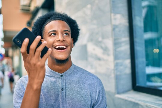 Young african american man smiling happy sending audio message using smartphone at the city.