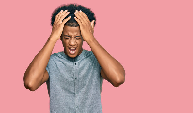 African american man with afro hair wearing casual clothes suffering from headache desperate and stressed because pain and migraine. hands on head.