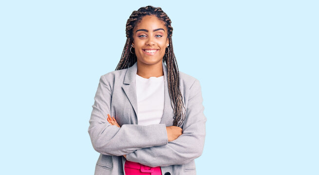 Young african american woman with braids wearing business clothes happy face smiling with crossed arms looking at the camera. positive person.