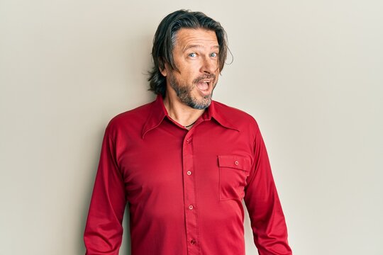 Middle age handsome man wearing casual clothes winking looking at the camera with sexy expression, cheerful and happy face.