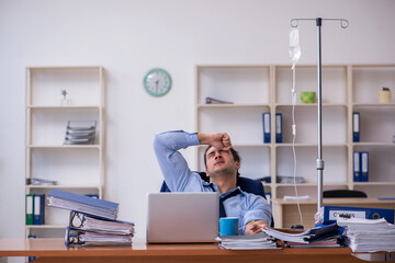 Young male employee suffering at workplace