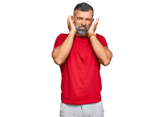 Fototapeta premium Middle age handsome man wearing casual clothes covering ears with fingers with annoyed expression for the noise of loud music. deaf concept.