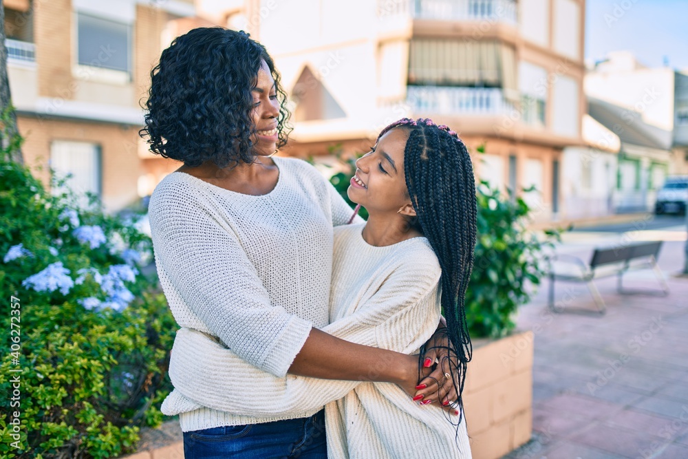 Poster beautiful african american mother and daughter smiling happy and hugging. standing with smile on fac