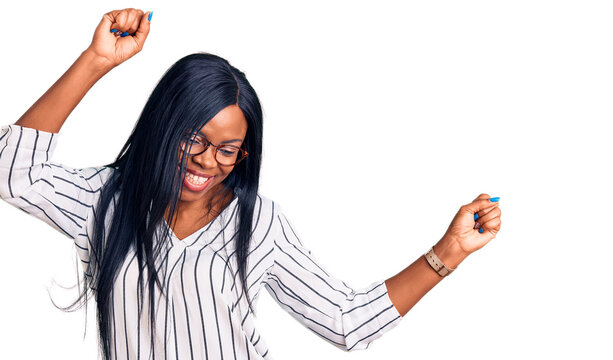 Young african american woman wearing casual clothes and glasses dancing happy and cheerful, smiling moving casual and confident listening to music