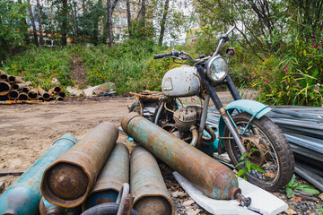 Old motorcycle on the background of oxygen cylinders, Scrap yard, metal for recycling.