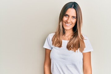 Brunette young woman wearing casual white t shirt with a happy and cool smile on face. lucky person.