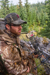 Bowhunter sitting quietly in the forest of Oregon Cascades