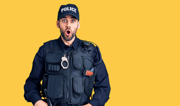 Young handsome man with beard wearing police uniform afraid and shocked with surprise expression, fear and excited face.