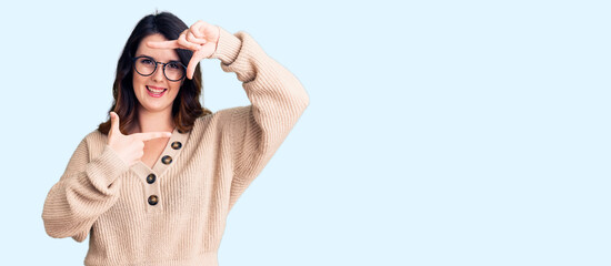 Beautiful young brunette woman wearing casual clothes and glasses smiling making frame with hands and fingers with happy face. creativity and photography concept.