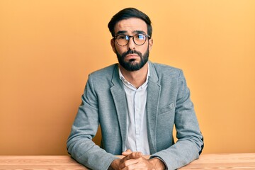 Young hispanic man working at the office depressed and worry for distress, crying angry and afraid. sad expression.