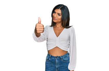 Young latin transsexual transgender woman wearing casual clothes looking proud, smiling doing thumbs up gesture to the side