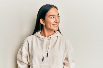 Young asian woman wearing casual sweatshirt looking to side, relax profile pose with natural face and confident smile.