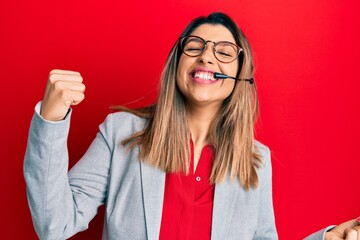 Beautiful brunette woman working at the office wearing operator headset very happy and excited doing winner gesture with arms raised, smiling and screaming for success. celebration concept.